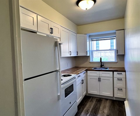 a kitchen with white cabinets and a white refrigerator